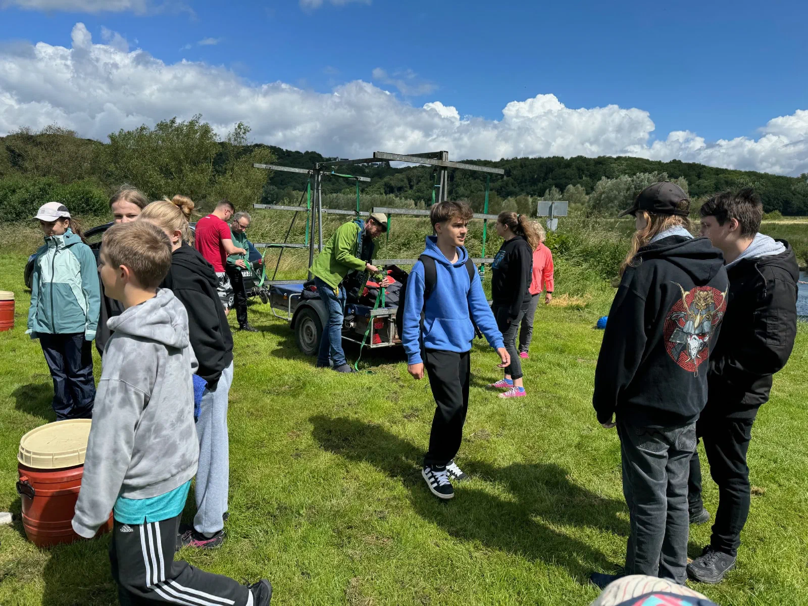 Jugendliche und Betreuer warten auf der Wiese