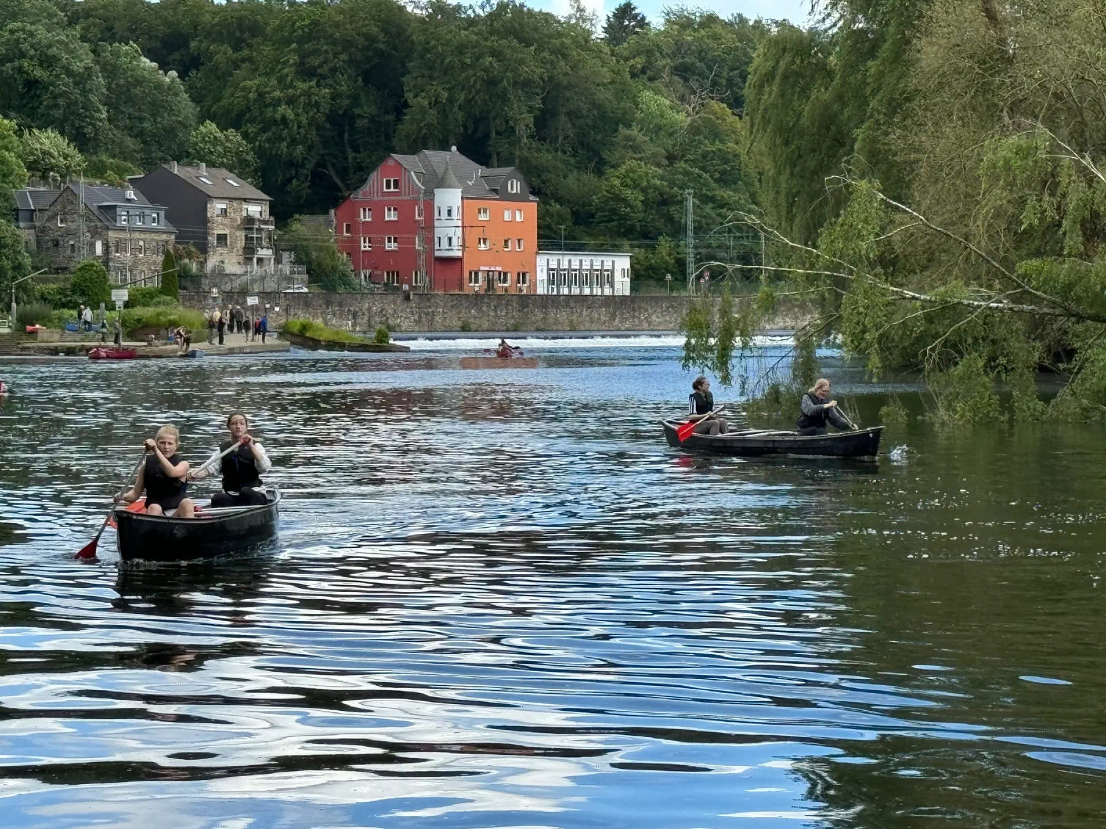 Kanus auf der Ruhr, im Hintergrund rote Häuser am Ufer
